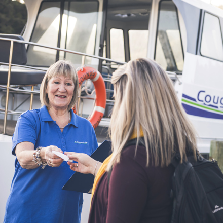 A passenger is greeted by a smiling Cougar Line staff member while boarding in Picton in the Marlborough Sounds, New Zealand.