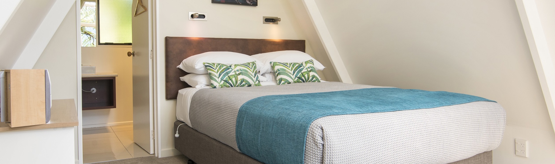 The interior of an A-frame Koru Chalet at Punga Cove, with a queen sized bed and ensuite, in the Marlborough Sounds, New Zealand